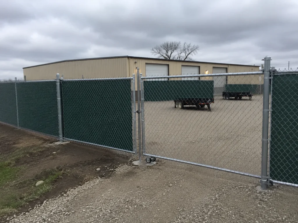 Detailed view of green privacy slat chain link commercial fence in Center Point, Iowa