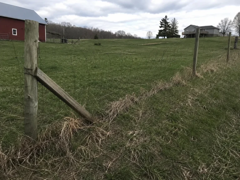 Close view of rustic post and wire farm fence in Hiawatha, Iowa