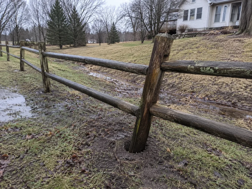 Detailed view of rustic split rail fence in a residential yard in Cedar Rapids, Iowa