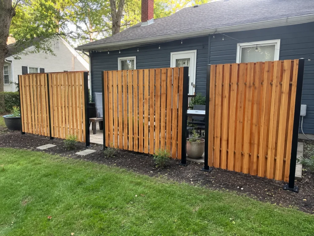 Close view of vertical cedar privacy fence with black posts in Cedar Rapids, Iowa