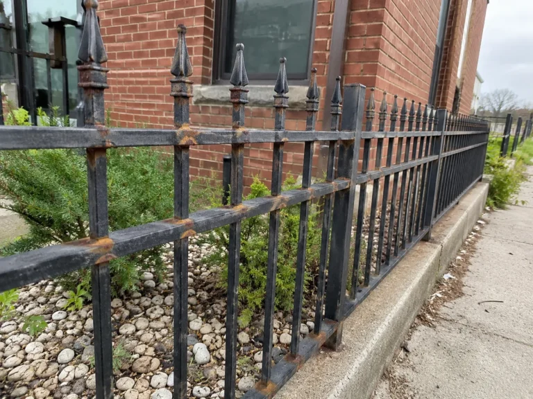 weathered ornamental iron fence shown at a property in Cedar Rapids, Iowa