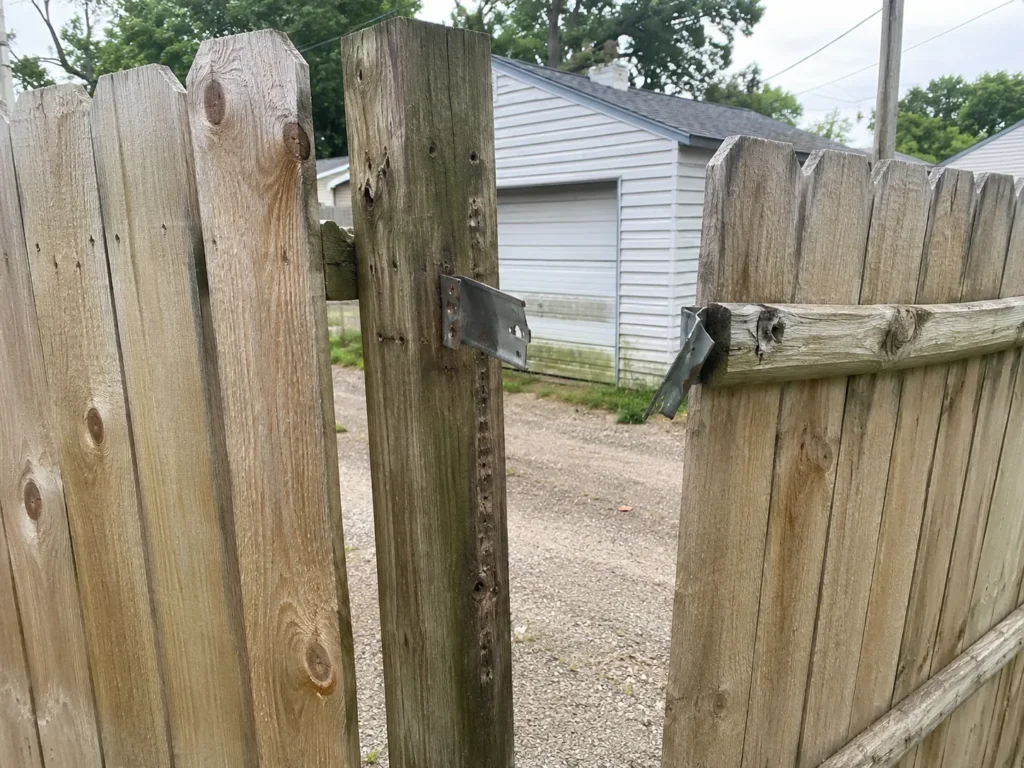 weathered wood privacy gate hinge repair at an Eastern Iowa property in Cedar Rapids