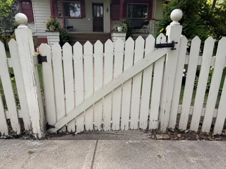 Detailed view of white wood picket gate repair in Cedar Rapids, Iowa